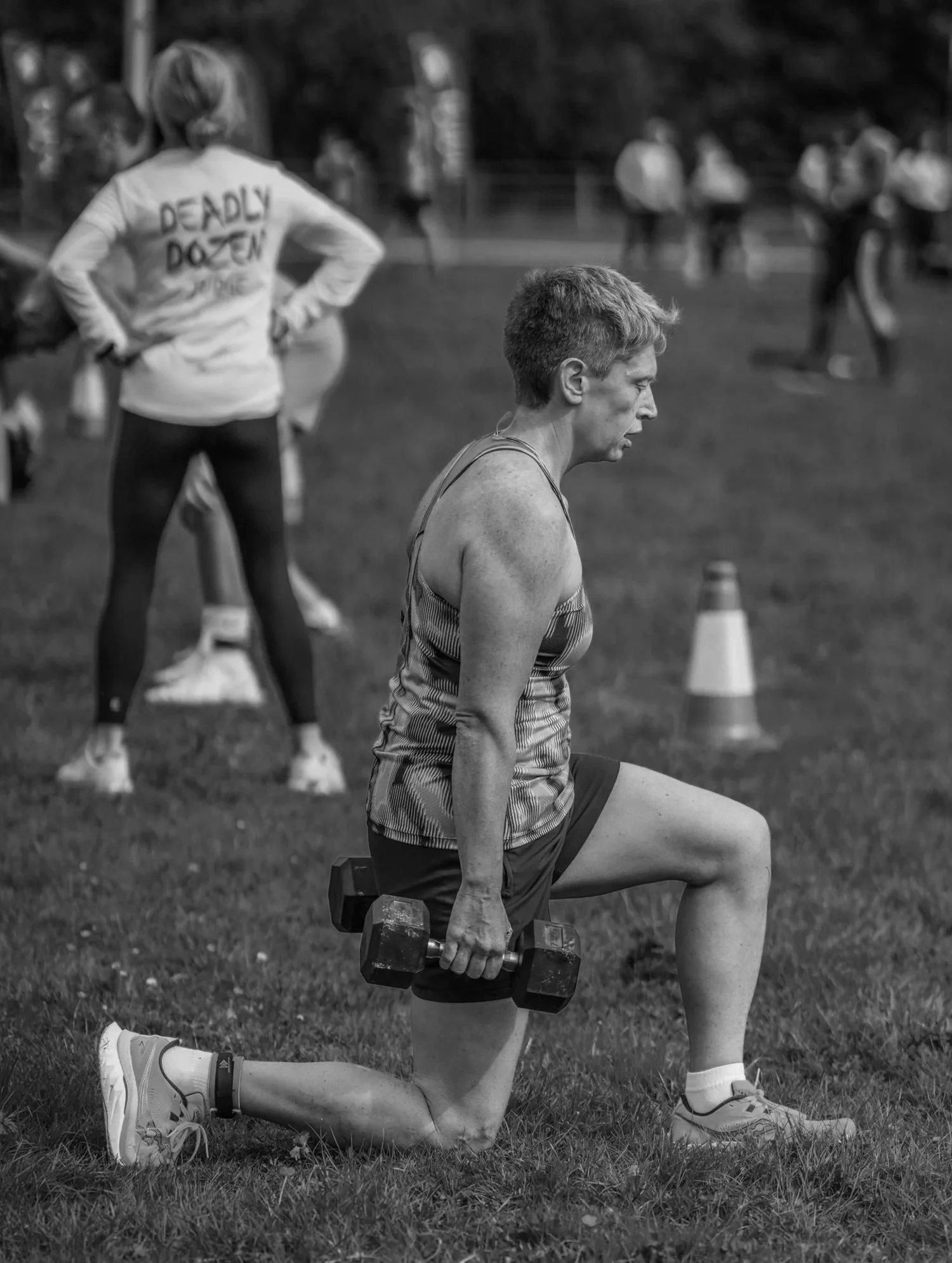 Atleet die tijdens de Lunge Labour walking lunges met halters uitvoert
